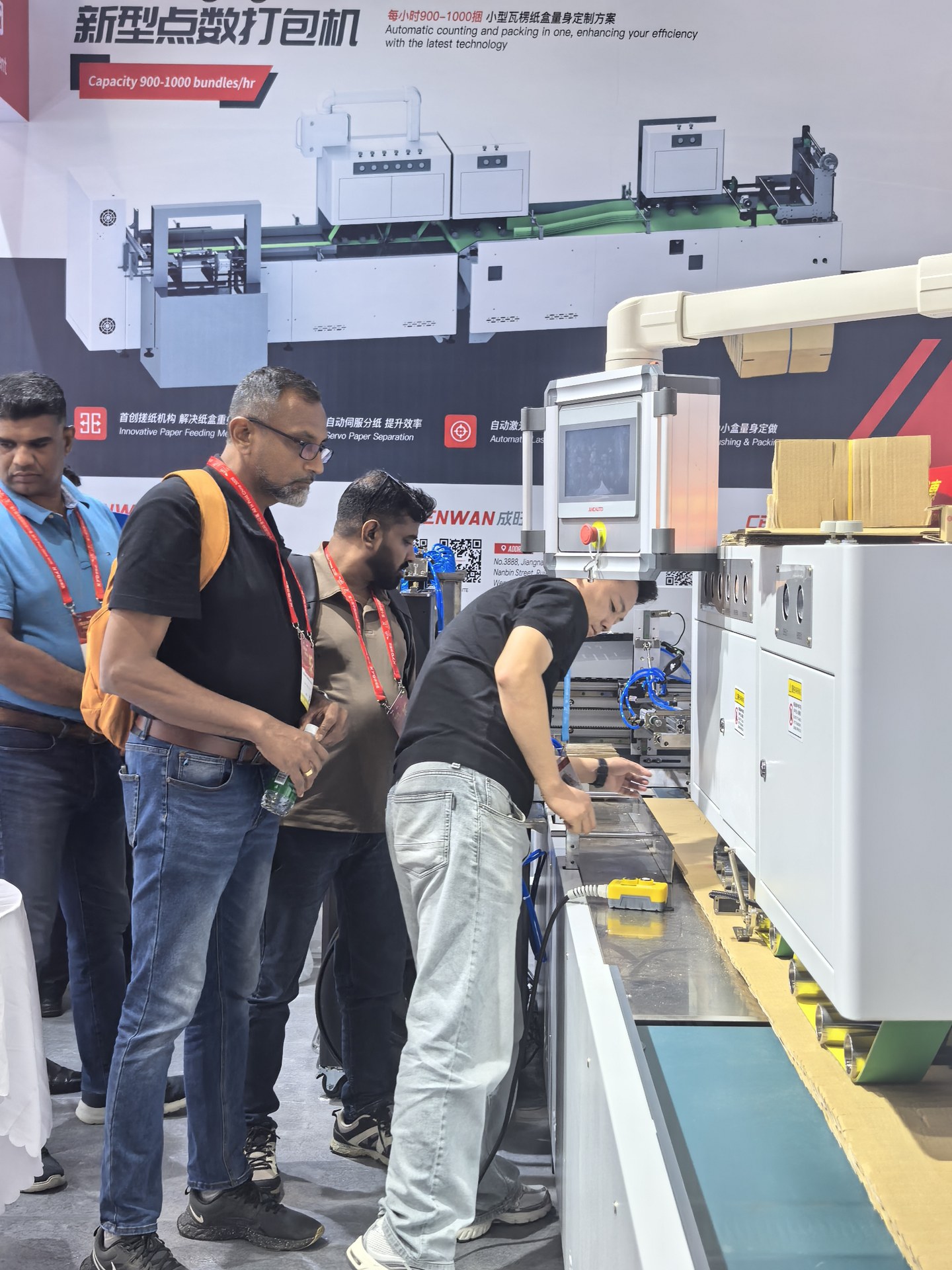 Visitors observing a Cenwan carton-box packaging machine at the exhibition
