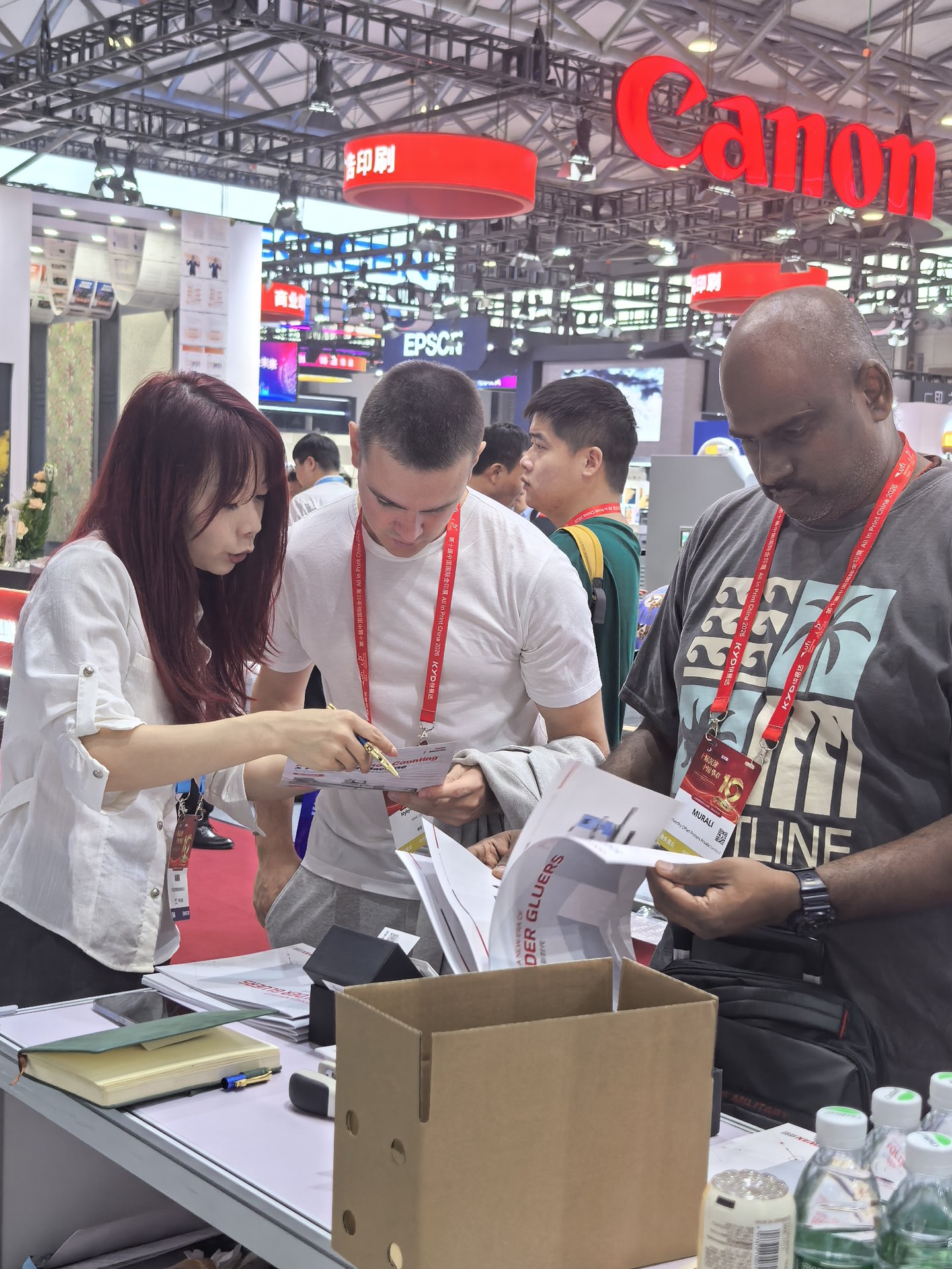 Cenwan staff discussing printed material with visitors at ALL IN PRINT CHINA 2026